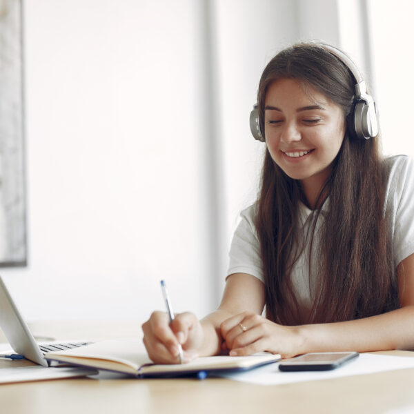 young student sitting at the table and use the laptop