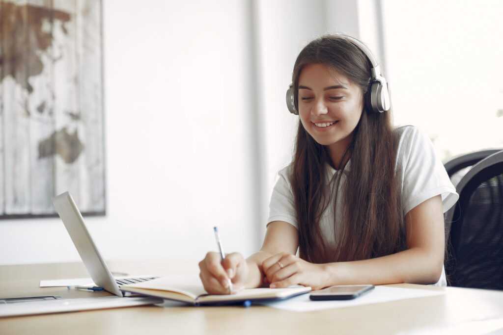 young student sitting at the table and use the laptop